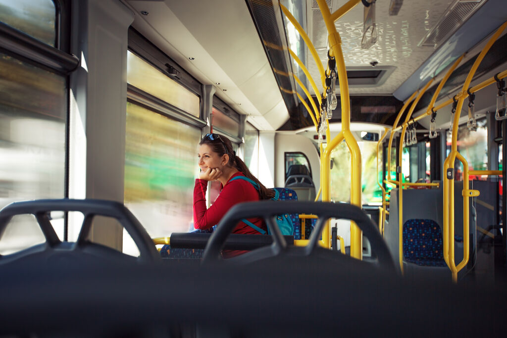 Ładna, młoda kobieta wyglądająca przez okno tramwaju, podczas dojazdu do pracy/szkoły