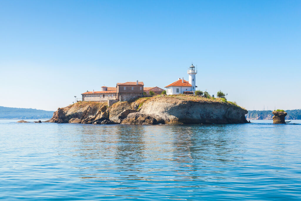 Wyspa Saint Anastasia w zatoce Burgas, Morze Czarne, Bułgaria. Wieża latarni i stare drewniane budynki na skalistym wybrzeżu