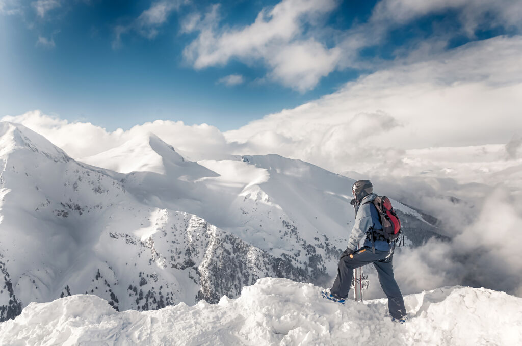 narciarz pobyt z nartami na dużej skale na tle gór. Bansko, Bułgaria